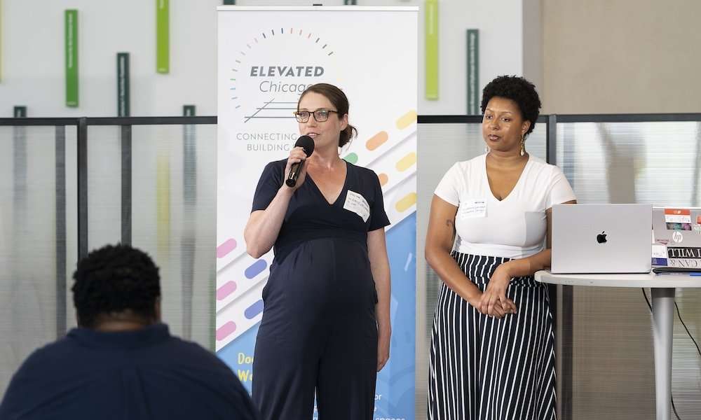 Emily Laflamme, with mic, reflects on the impact of the Elevated Works technical assistance program for community developers.